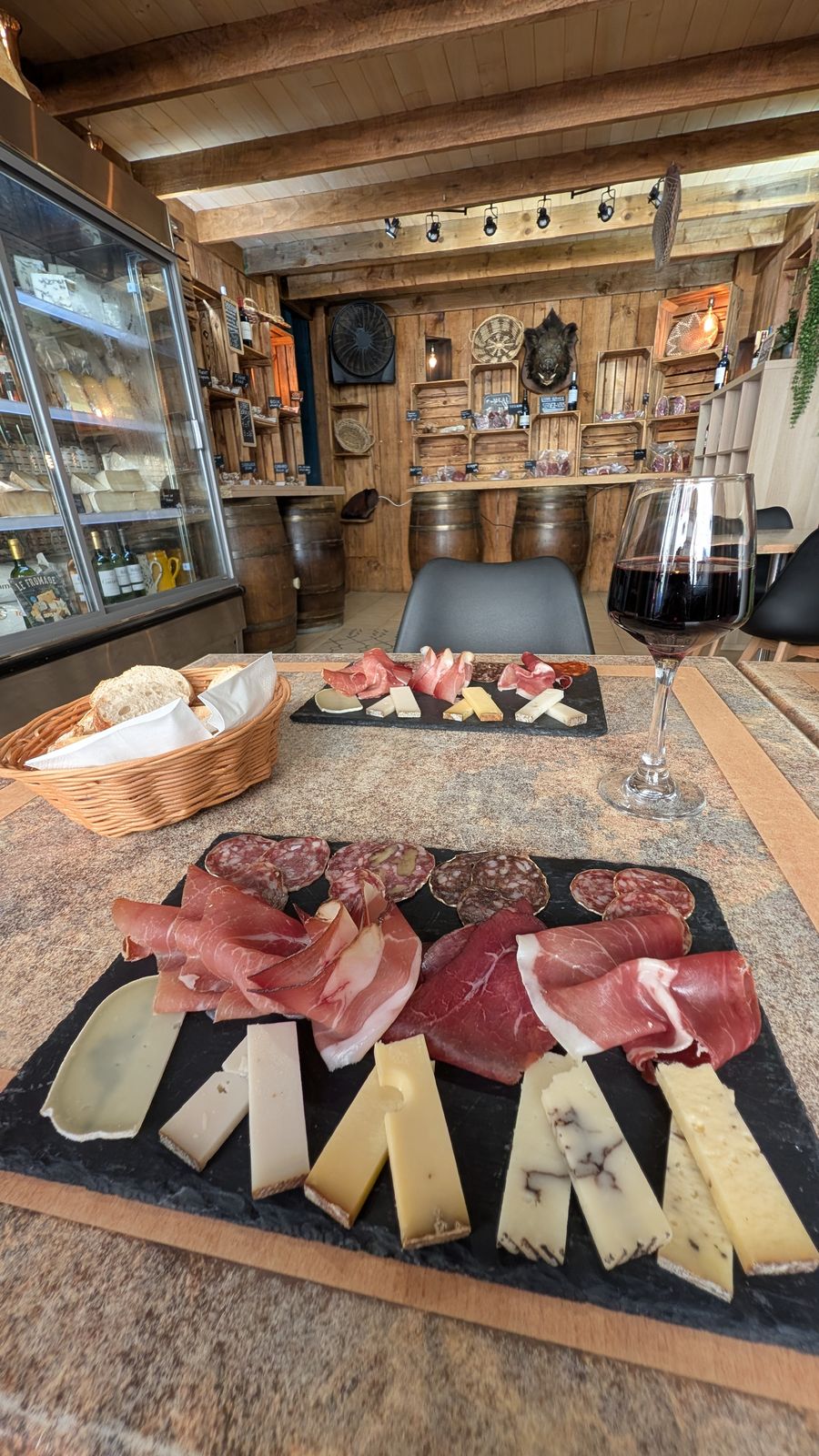 A tasting platter of local cheese and charcuterie with a glass of red wine in Domme