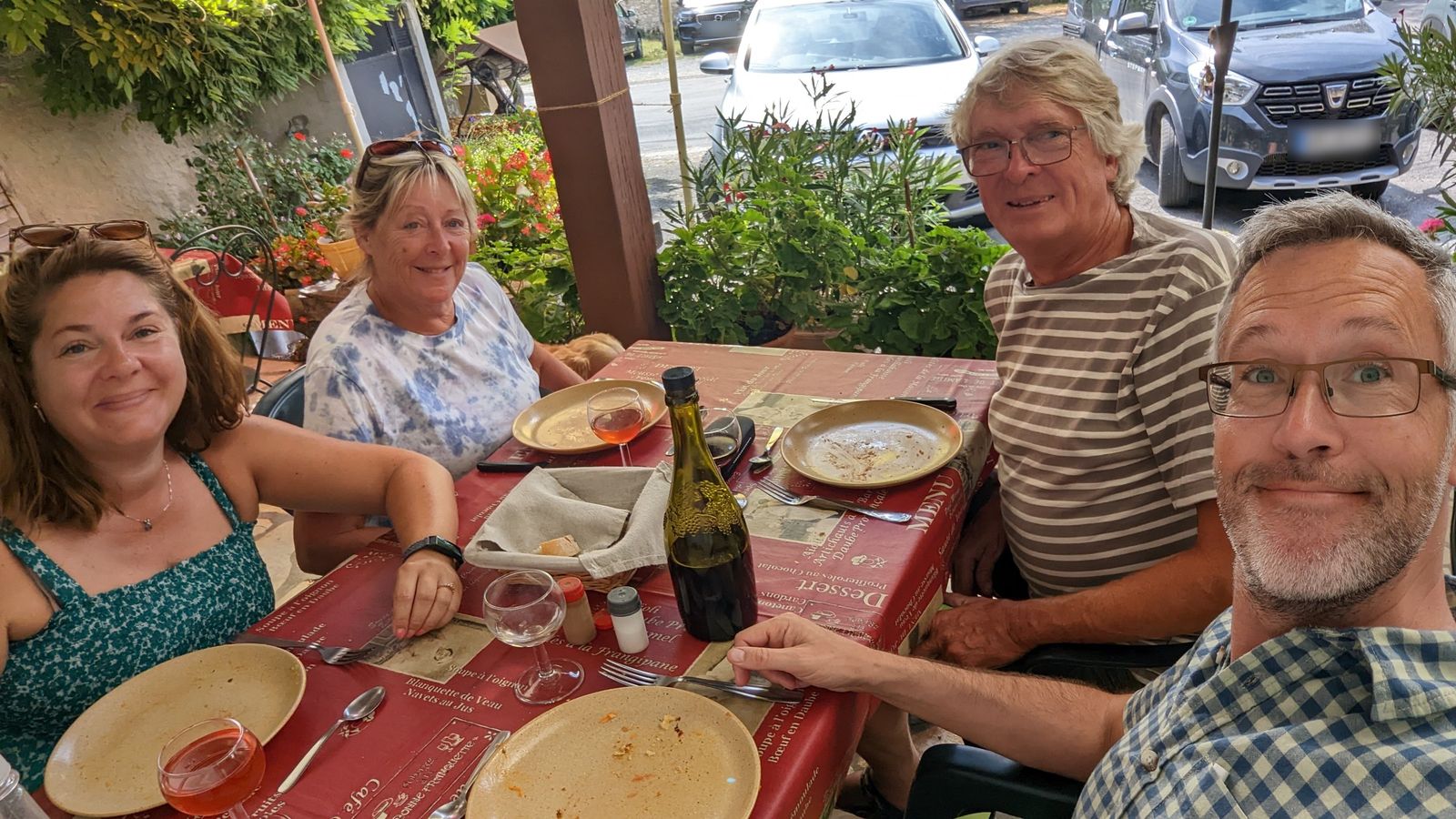Cassie, Val, Keith and Kev smiling around a table on a restaurant terrace