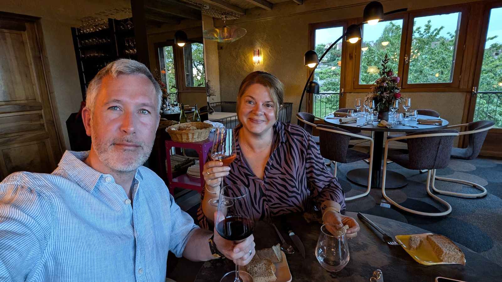 Kev and Cassie raising their glasses at a restaurant table