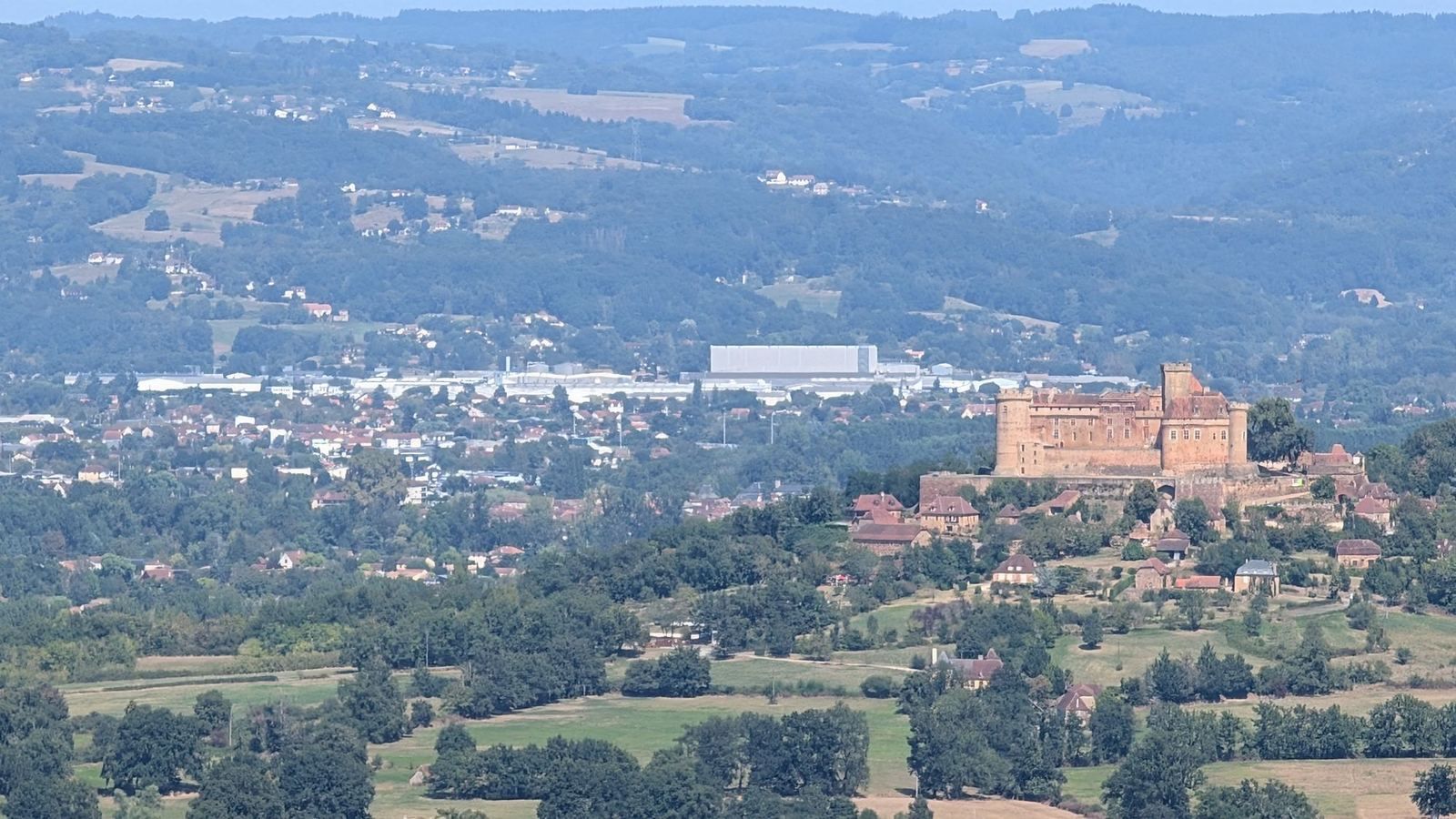 The red Château de Castelnau on its hill above the valley