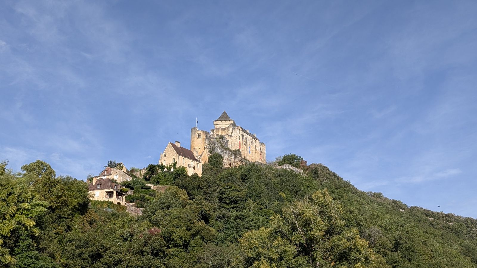 The Château de Castelnaud on its wooded hill, with houses of the village below