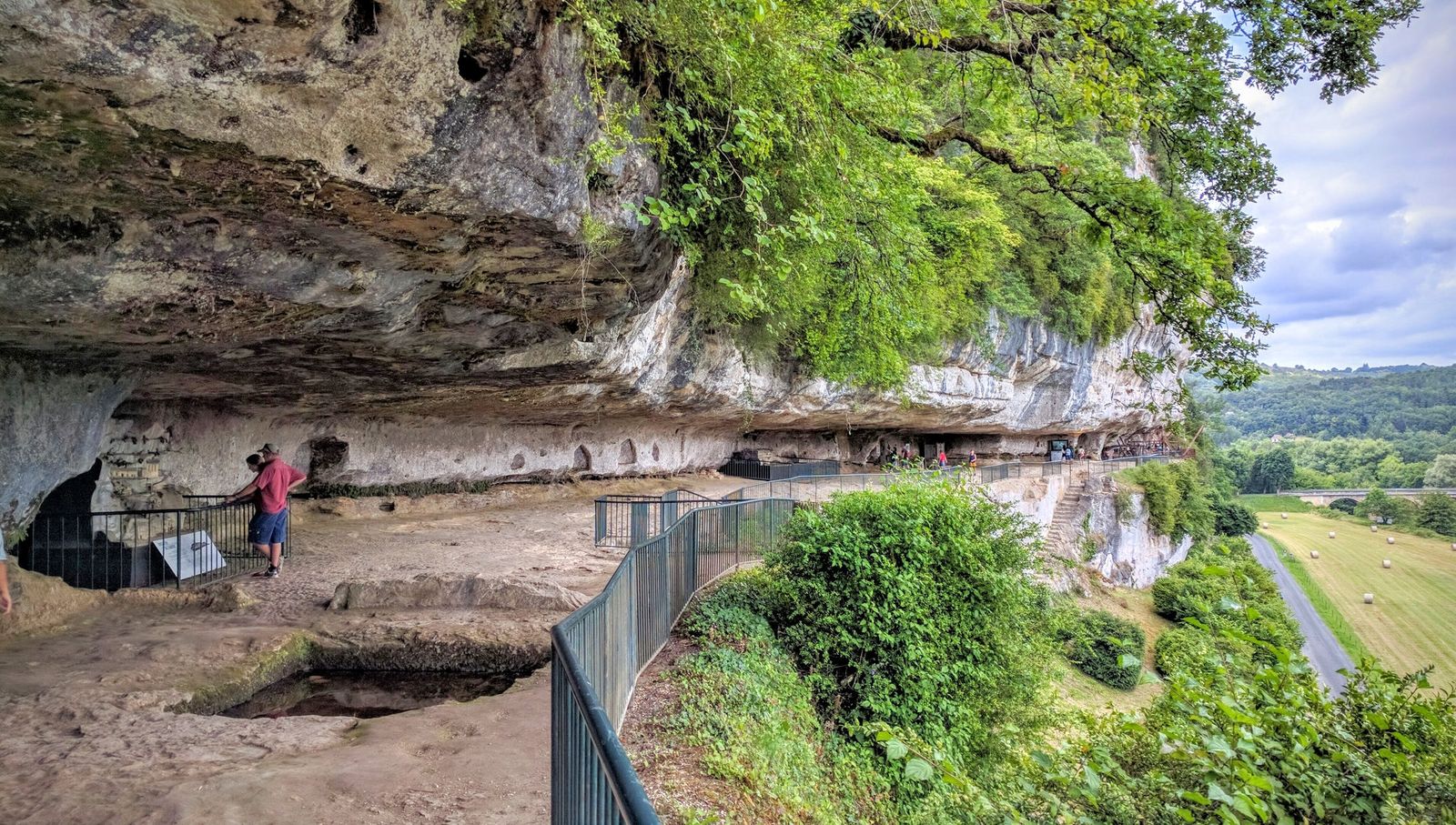 Walking under the rock overhang at La Roque Saint-Christophe