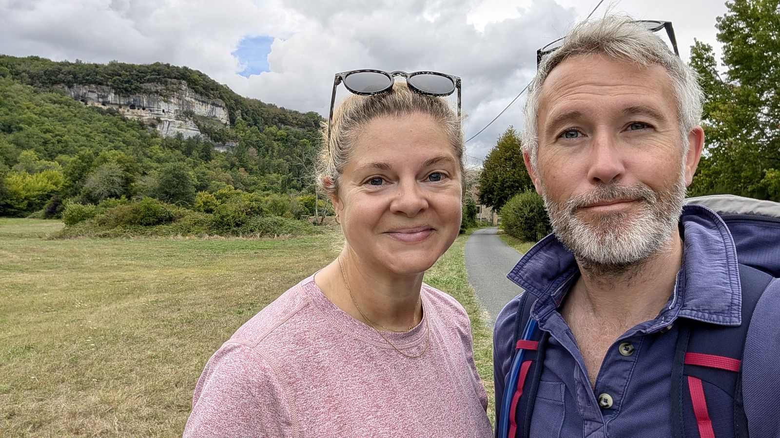 Kev and Cassie taking a selfie on a path below the limestone cliffs at Les Eyzies
