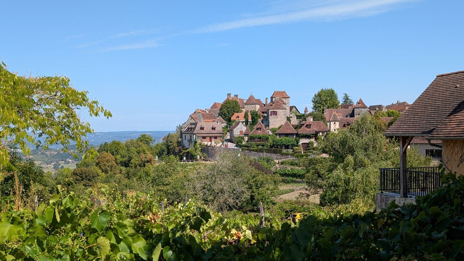 The stone houses of Loubressac on a clifftop above wooded countryside