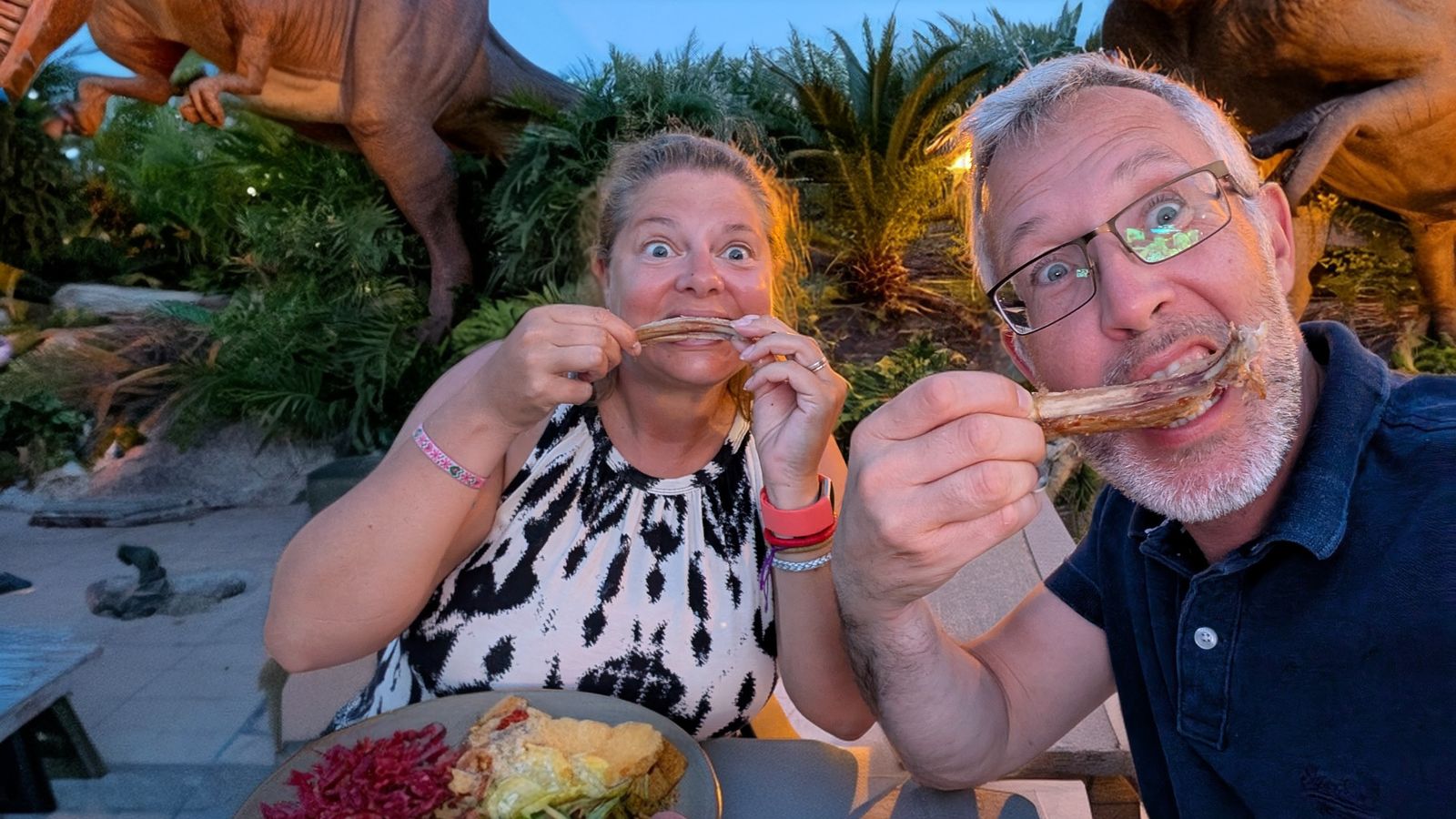 Kev and Cassie pulling faces as they eat dinner on a terrace at Loubressac