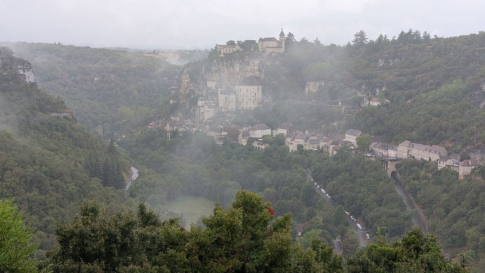 Rocamadour stacked up its cliff above the wooded gorge, half hidden in mist