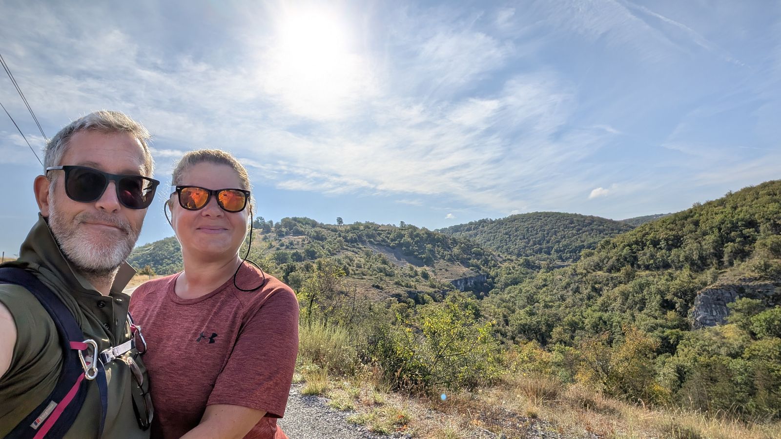 Kev and Cassie smiling on a track above a wooded valley near Rocamadour