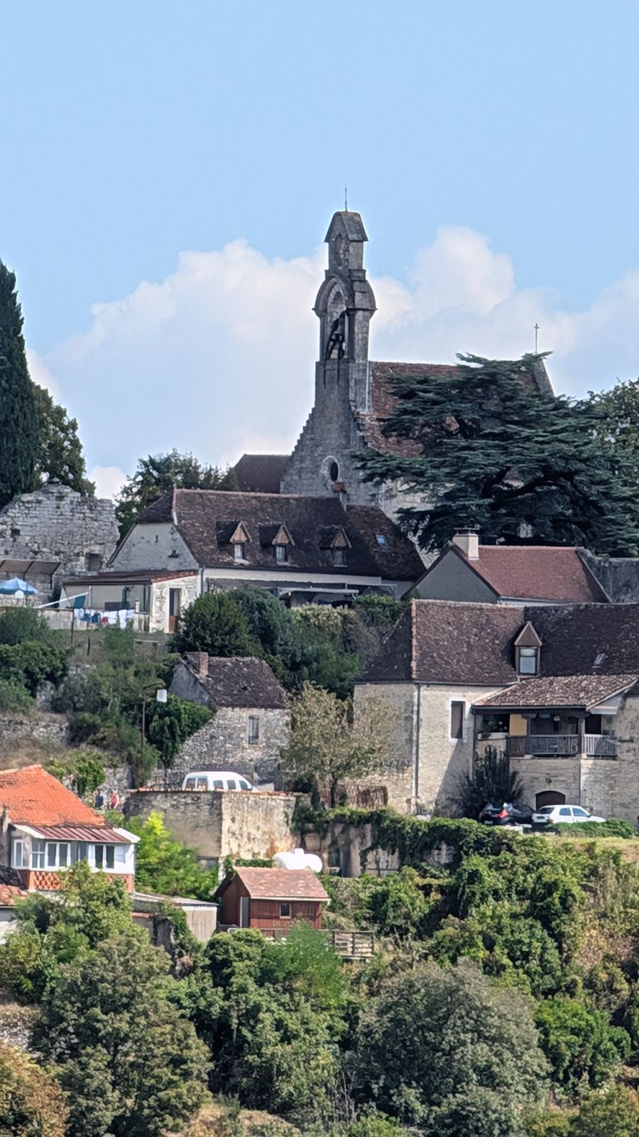 Stone houses climbing the hillside below a château on the cliff at Rocamadour