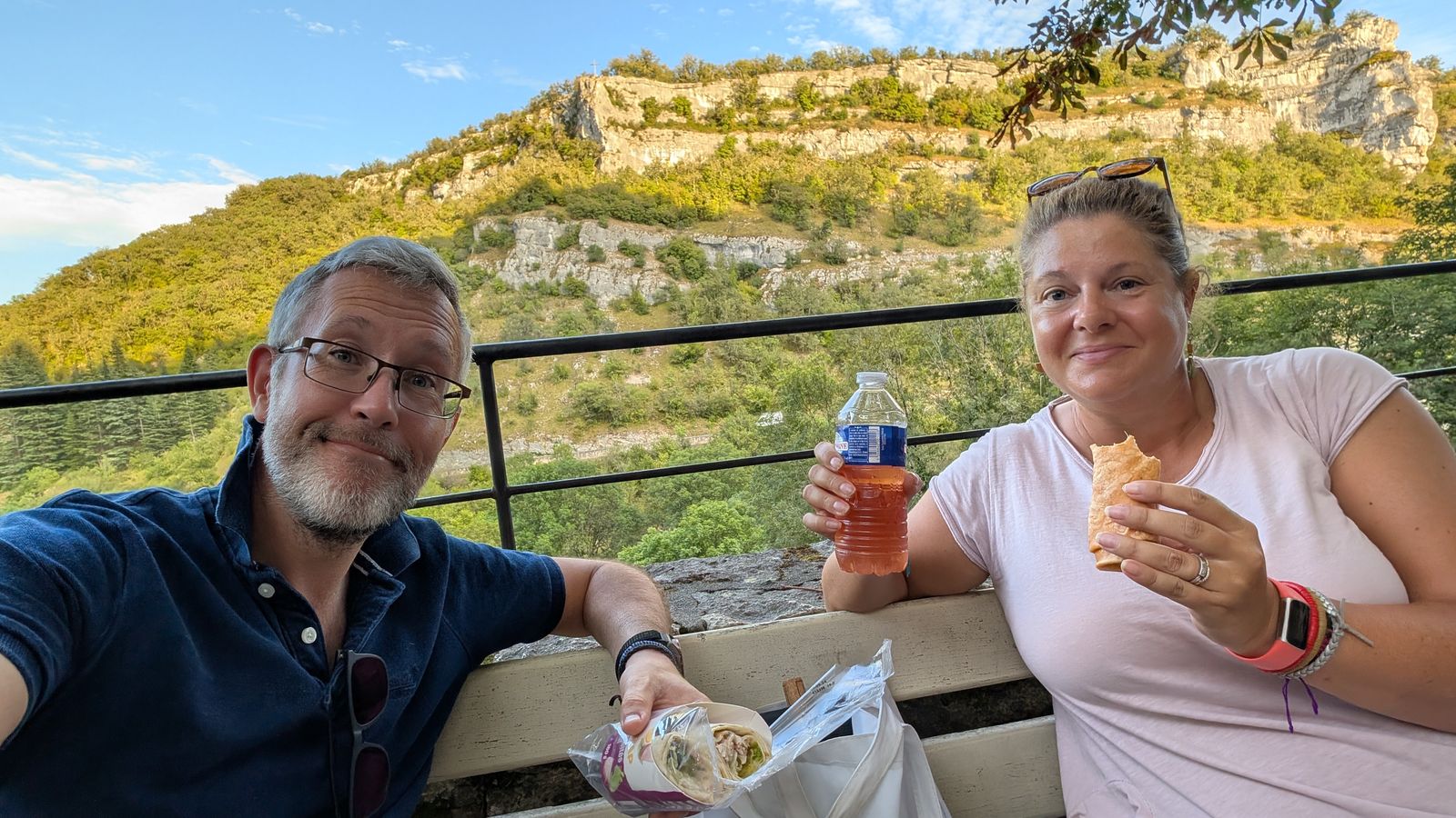 Kev and Cassie with a drink, Rocamadour’s cliffs behind them