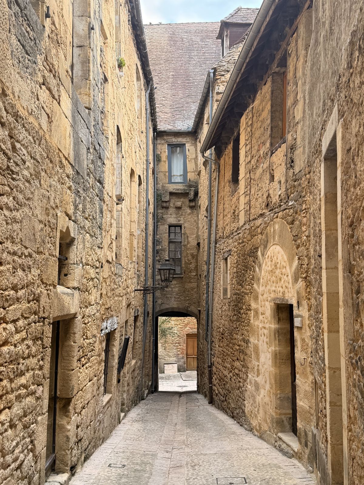 A narrow lane between tall stone houses in Sarlat’s old town