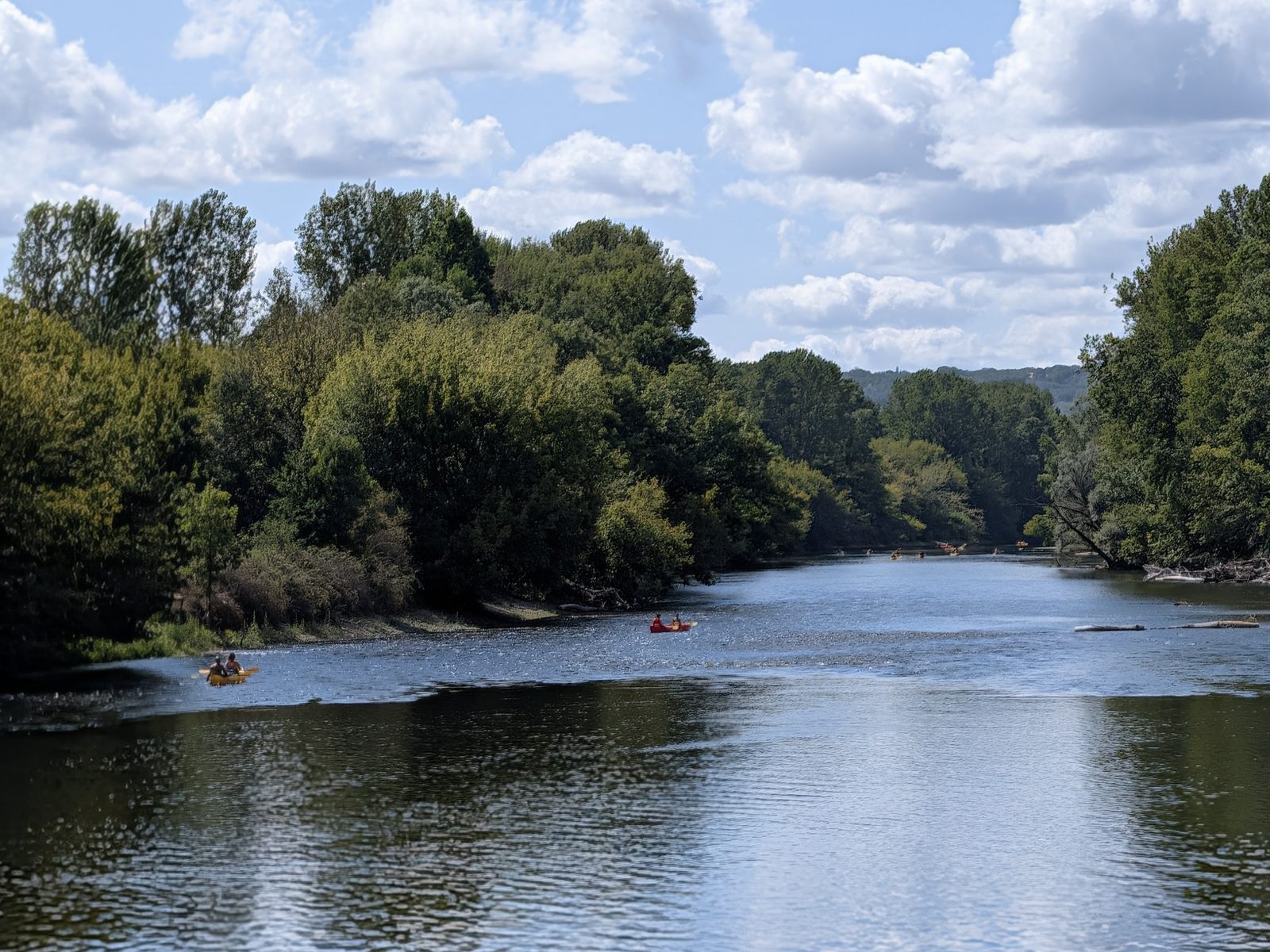 The Dordogne at Beynac between wooded banks, with canoes on the river