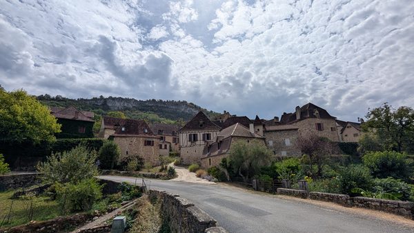 A quiet lane curving into the golden-stone village of Loubressac