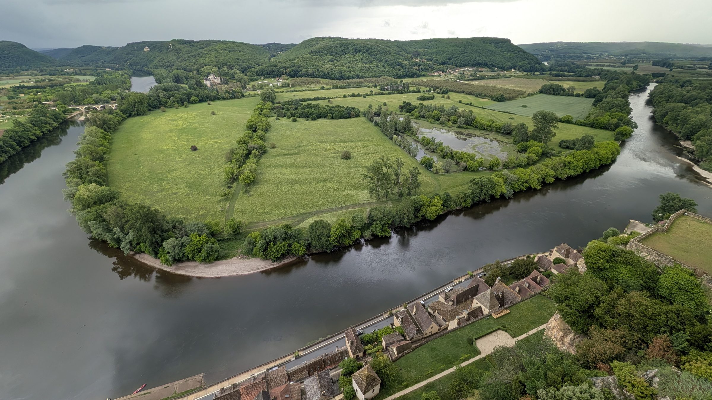 A wide loop of the Dordogne between green fields, seen from the château at Beynac