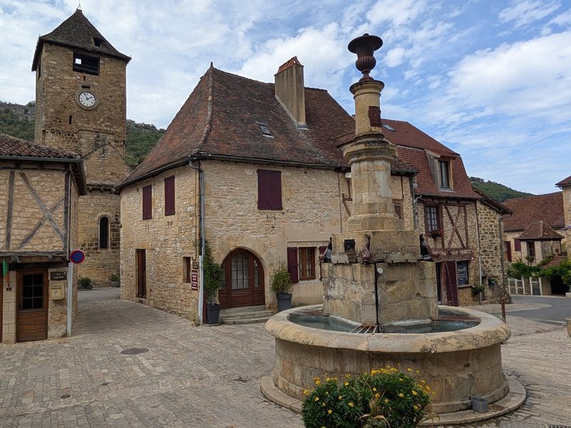 The fountain square in Autoire, with its clock tower and old stone houses