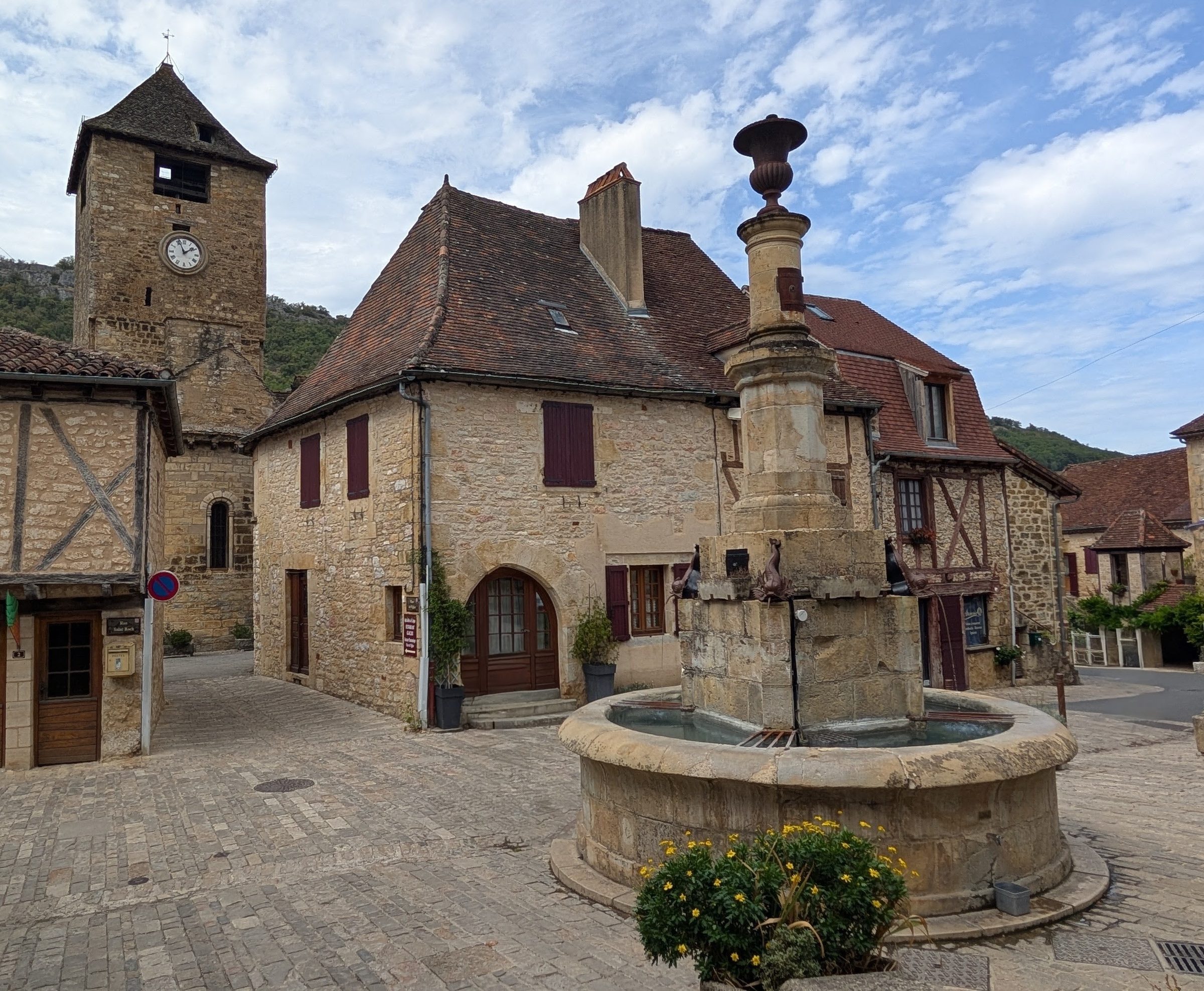 The fountain square in Autoire, with its clock tower and old stone houses