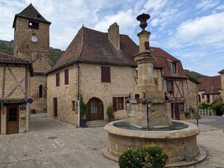 The fountain square in Autoire, with its clock tower and old stone houses