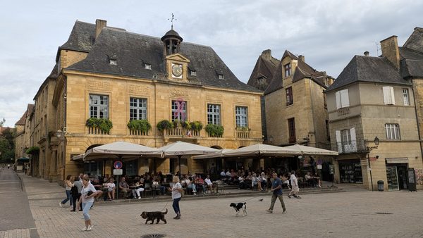 Café terraces and golden-stone houses on Place de la Liberté in Sarlat